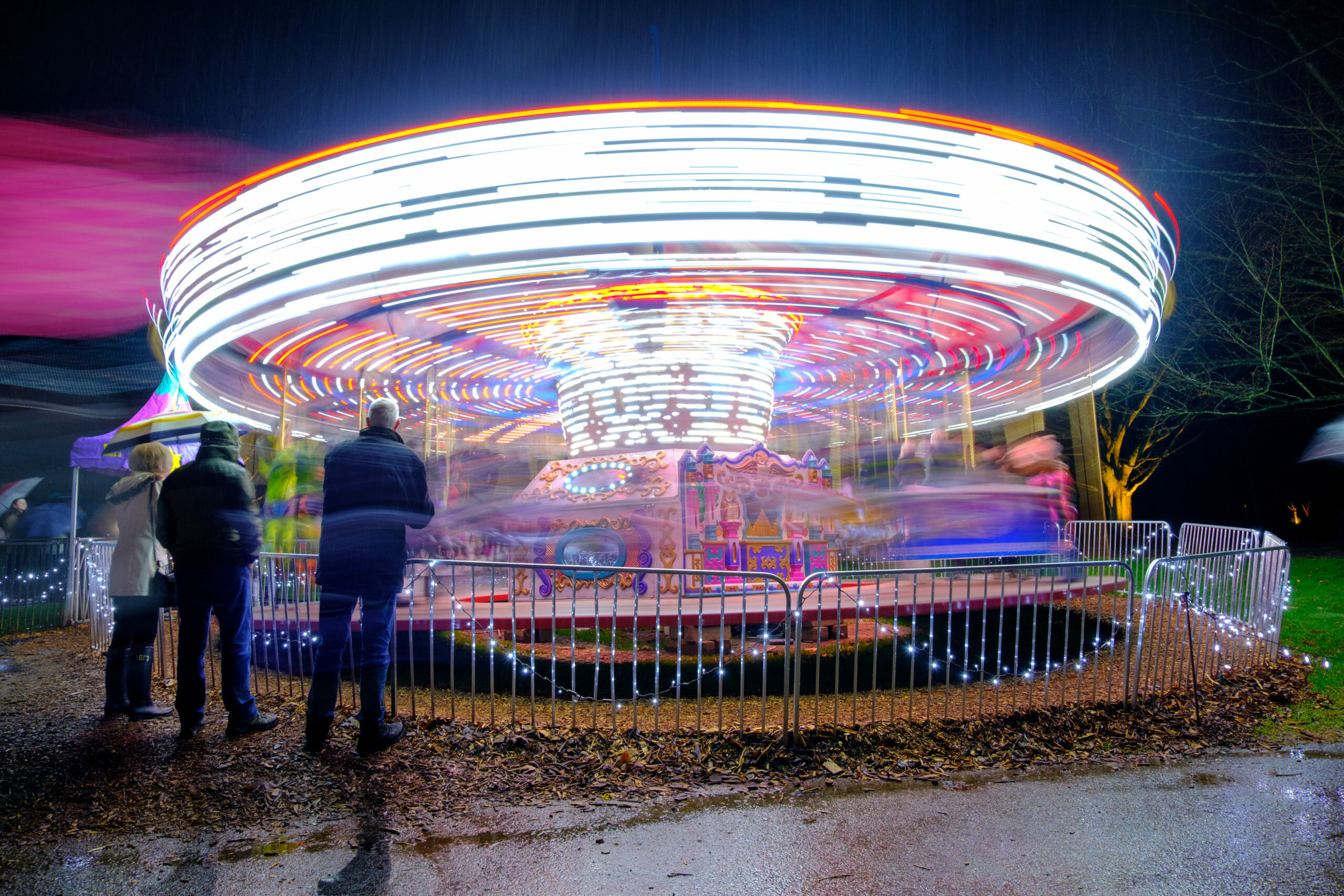 Long exposure of colourful carousel spinning at night at VanDusen Garden Festival of Lights decorated by Christmas lights