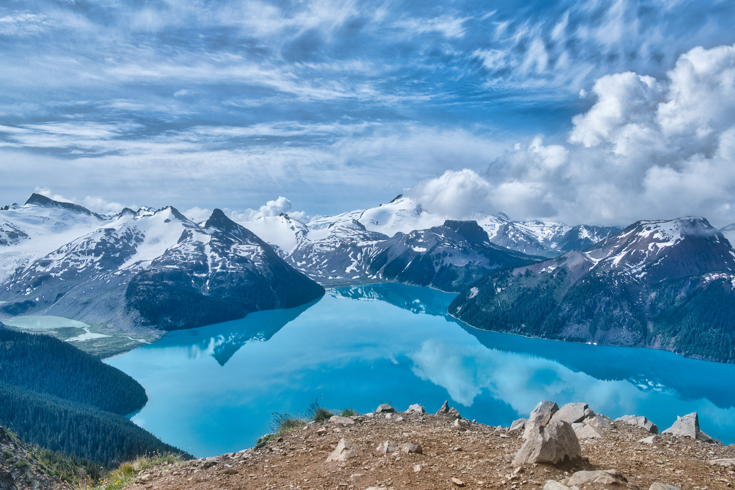 Summit of Panorama Ridge looking down on Garibaldi Lake surrounded by mountains and blue skies in Garibaldi Provincial Park