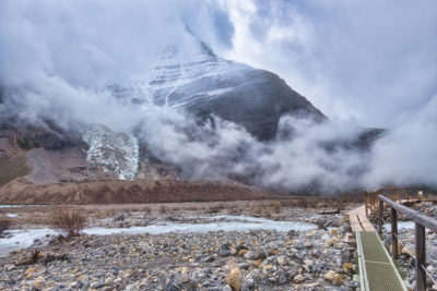 Mount Robson enshrouded in fog by bridge near Marmot campground on Berg Lake Trail in Mount Robson Provincial Park