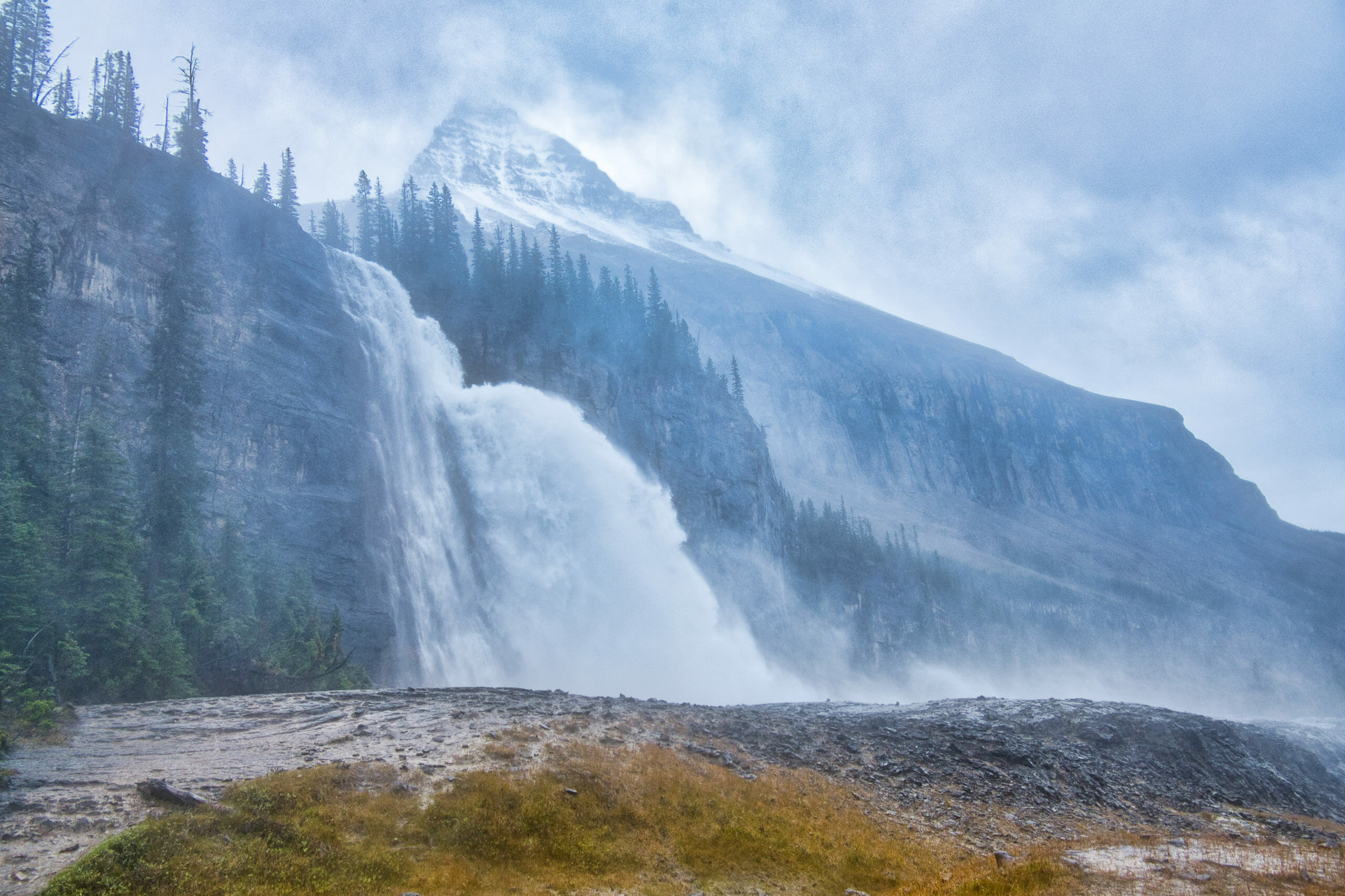 Emperor Falls in Mount Robson Provincial Park with Mount Robson in background on rainy day with heavy winds